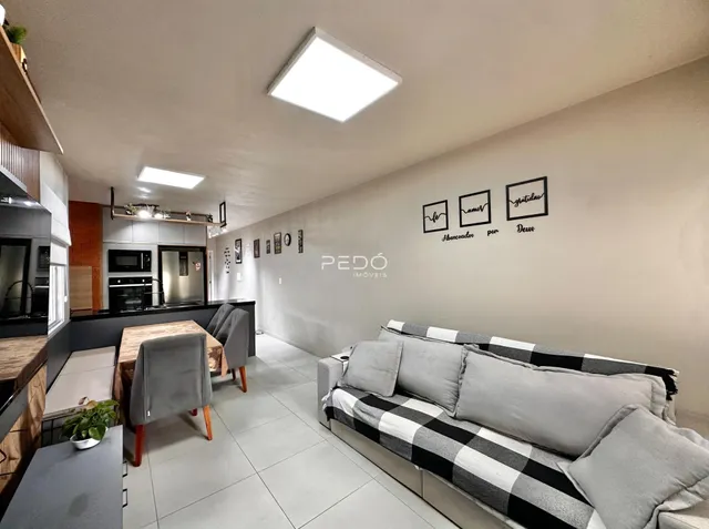 Interior de uma sala de estar com cozinha em um imóvel no Brasil.