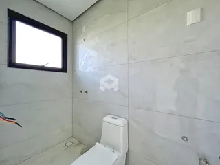 Foto de um banheiro com revestimento de parede em tons de cinza.