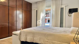 Quarto com armários de madeira e janela iluminada.