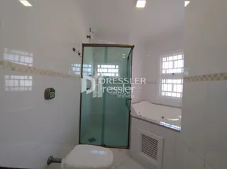 Foto de um banheiro interno com azulejos brancos.