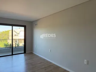 Ambiente interno com piso de madeira e paredes brancas.
