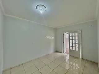 Ambiente interno com piso de cerâmica claro e paredes brancas.
