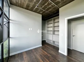 Ambiente interno com piso de madeira e parede branca em um imóvel.