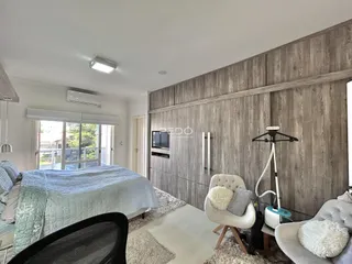 Quarto com parede de madeira e vista para o exterior.