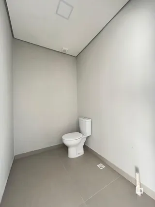 A foto mostra um banheiro simples com vaso sanitário.