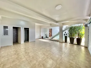 Ambiente interno amplo com piso de cerâmica claro.