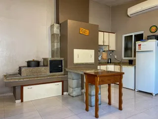 Foto de uma cozinha com lareira e armários em um imóvel.