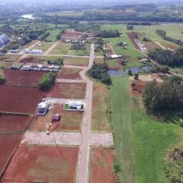 Vista aérea de uma área rural com campos agrícolas e vegetação.