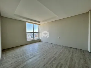 Uma sala de estar vazia com vista para a cidade.