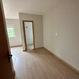 Hall de entrada com piso de madeira clara.