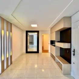 Hall de entrada com piso claro e iluminação uniforme.
