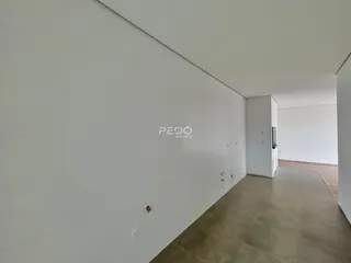 Corredor interno de uma residência com paredes brancas e piso claro.