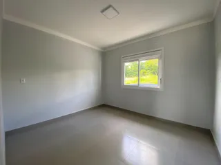 Foto de um cômodo interno com paredes brancas e piso claro.