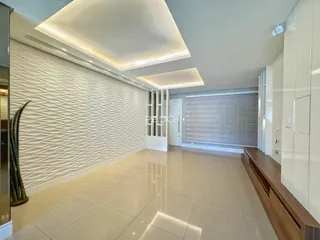 Sala de estar moderna com piso claro e parede texturizada em Lajeado.