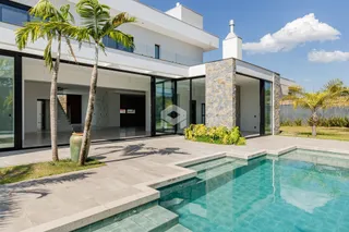Fachada de uma casa moderna com piscina e jardim em Lajeado.