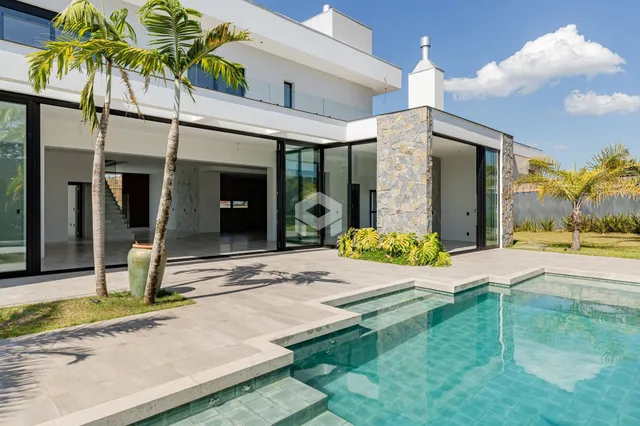 Fachada de uma casa moderna com piscina e jardim em Lajeado.