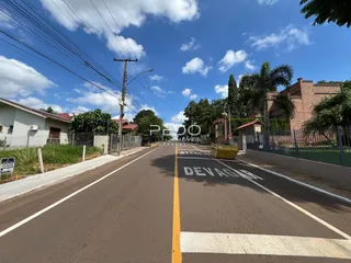 Vista da rua em Lajeado, Brasil, mostrando casas e sinalização de trânsito.