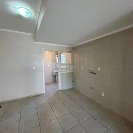 Corredor com paredes brancas e piso de cerâmica.