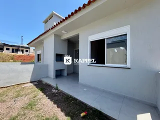 Fachada externa de uma residência com telhado de telhas e paredes brancas.