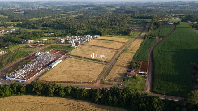 Vista aérea de uma área de terras com campos agrícolas e vegetação.