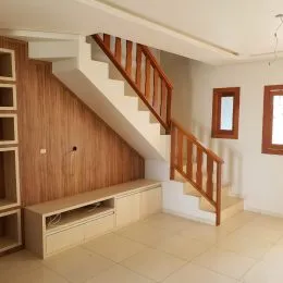 Foto de um corredor com escadas de madeira e painéis de madeira em um imóvel.