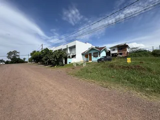 Fachada de residências em Lajeado, Brasil, ao longo de uma estrada de terra.