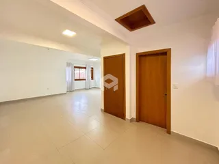 Vista interna de um corredor com paredes brancas e piso claro.