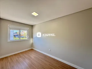 Uma foto de um cômodo interno com piso de madeira e janela.
