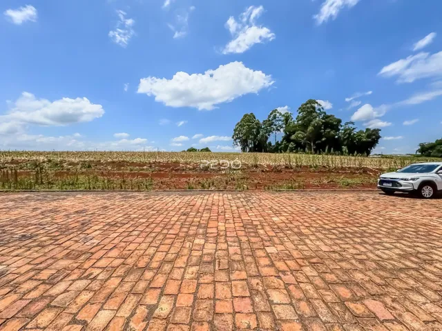 Vista de um campo de terra com um pátio de tijolos no Brasil.