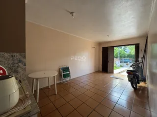 Interior de uma sala com piso de cerâmica e parede clara.