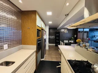 Cozinha moderna com armários de madeira e revestimento de azulejos.