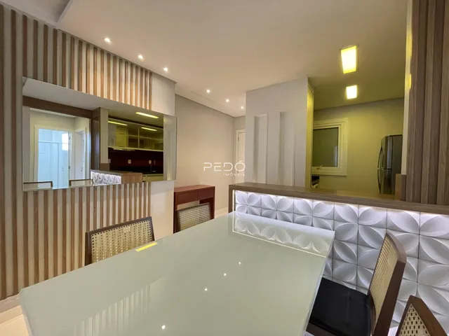 Ambiente moderno de sala de estar com detalhes em madeira e bancada branca.