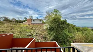 Vista da fachada de uma casa em Lajeado, Brasil, com vegetação densa ao fundo.