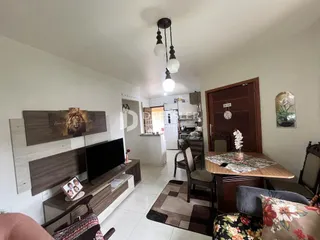 Sala de estar com móveis de madeira e televisão em um imóvel.