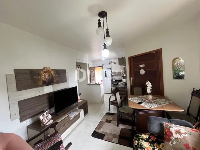 Sala de estar com móveis de madeira e televisão em um imóvel.