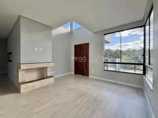 Sala de estar ampla com piso de madeira clara e grande janela.
