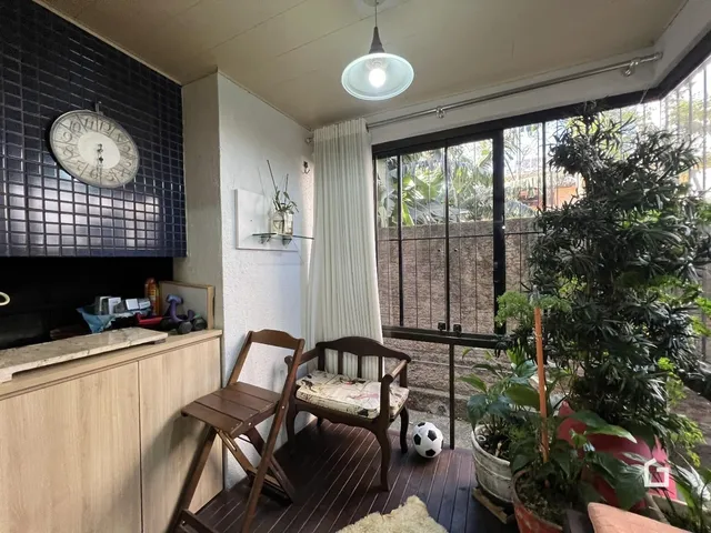 Ambiente interno com piso de madeira e vista para o exterior.
