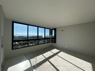 Ambiente interno com grande janela de vista para a paisagem.