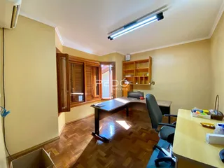 Ambiente interno com piso de madeira e móveis de escritório.