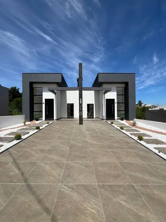 Fachada moderna de uma casa em Lajeado, Brasil, com entrada pavimentada.