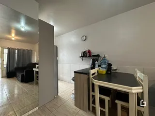 Ambiente interno com mesa de jantar e bancada na residência.