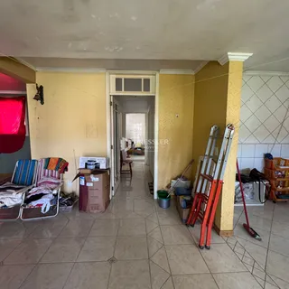Vista interna de um corredor com paredes amarelas e piso de cerâmica.