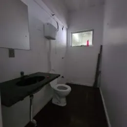 Foto de um banheiro interno mostrando a pia e o vaso sanitário.