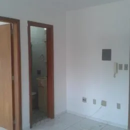 Hall de entrada com portas de madeira e paredes brancas.