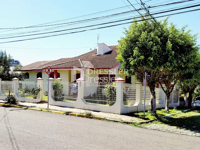 Fachada de uma casa residencial em Lajeado, Brasil, com cerca branca e telhado de telhas.