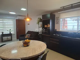 Sala de estar com mesa redonda e móveis escuros.