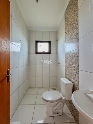 Interior de um banheiro com revestimento cerâmico branco.