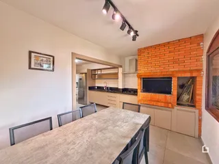 Vista de uma sala de jantar com parede de tijolos aparentes.