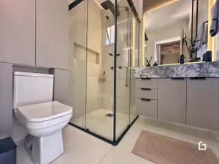 Foto de um banheiro moderno com box de vidro e revestimento de porcelanato.