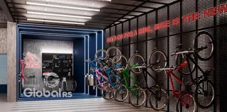 Uma parede com textura preta exibe bicicletas penduradas em um ambiente moderno.